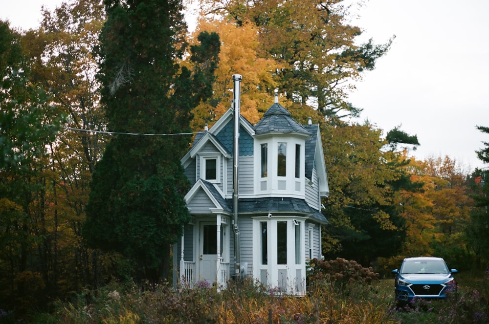 Casa di legno bianca e nera circondata da alberi
