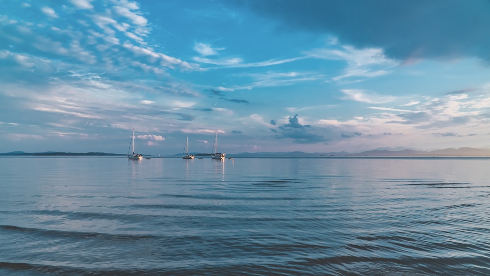 weißes Boot auf dem Meer unter blauem Himmel und weißen Wolken während des Tages