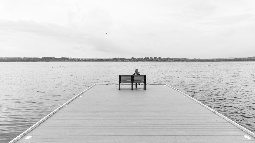 grayscale photo of wooden dock on body of water