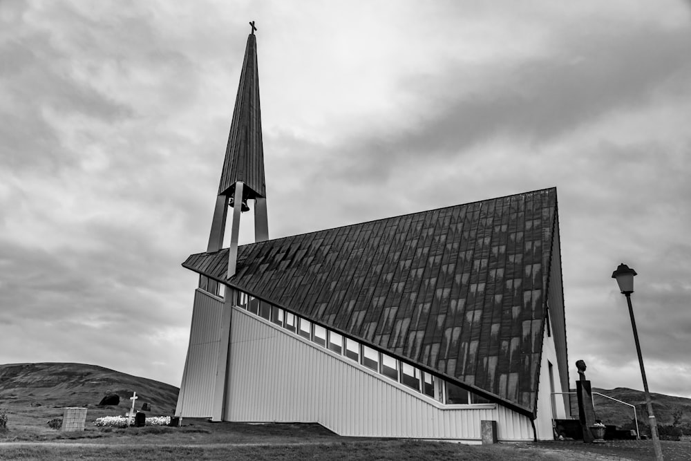 grayscale photo of building under cloudy sky