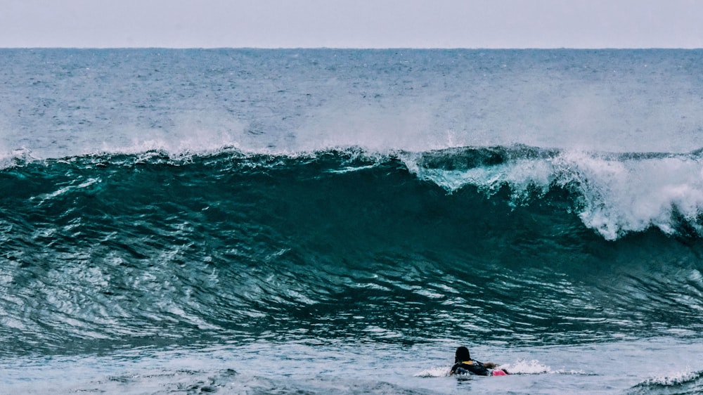 person surfing on sea waves during daytime