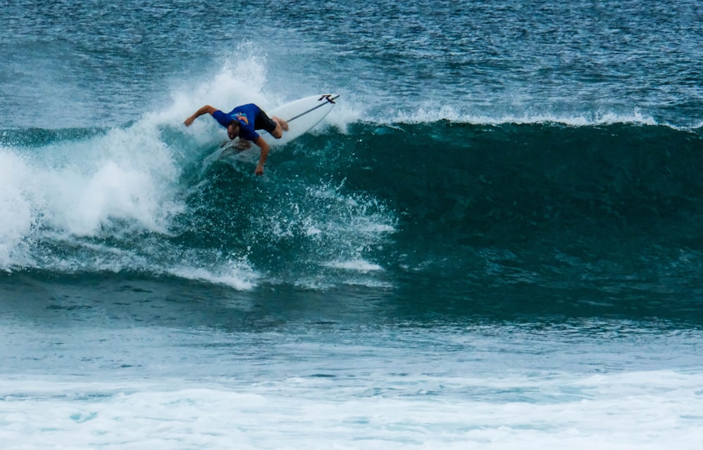 man surfing on sea waves during daytime