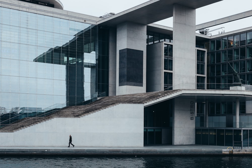 person walking on sidewalk near building during daytime