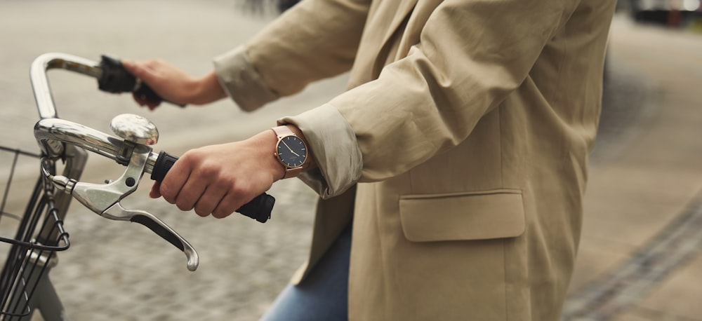 person in brown dress shirt and blue denim jeans wearing silver watch