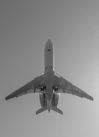 grayscale photo of airplane in mid air