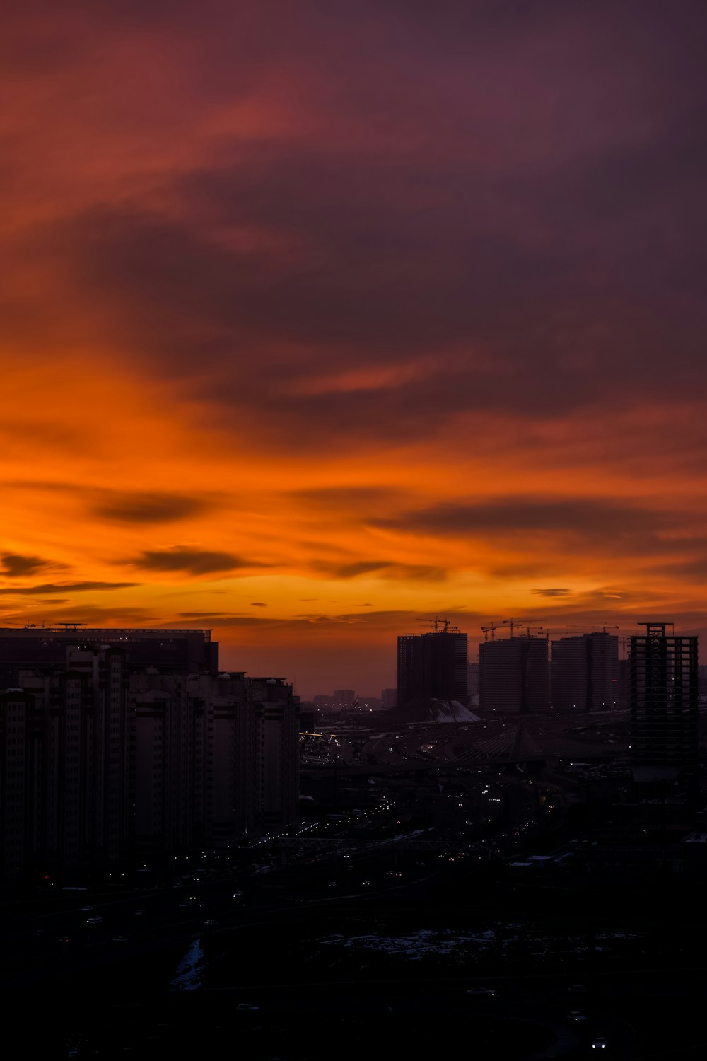 city skyline under orange and blue sky during sunset