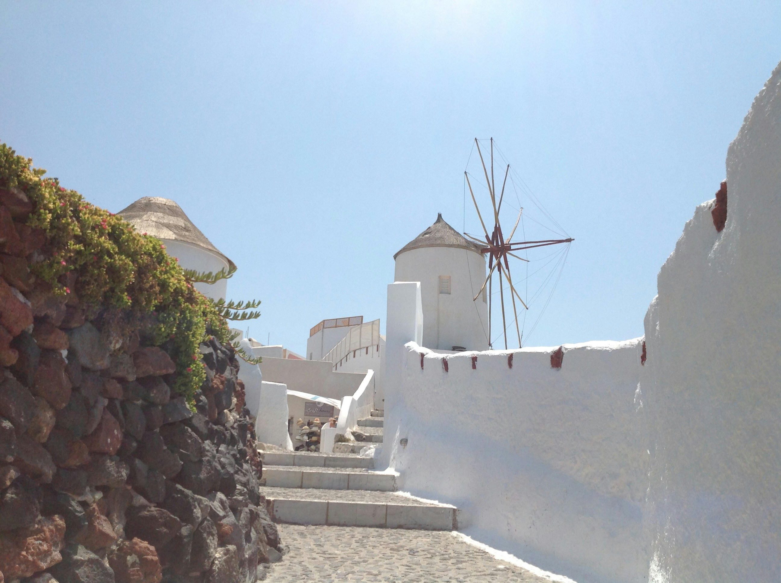 white and brown concrete building near green trees during daytime santorini teams background