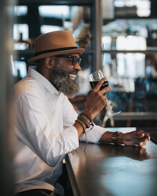 photography poses for men,how to photograph man in white dress shirt and brown hat holding clear drinking glass