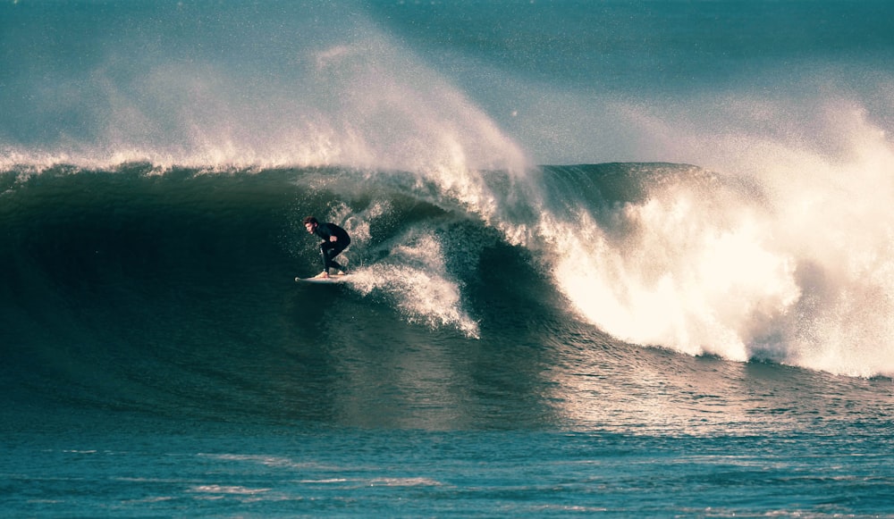 man surfing on sea waves during daytime