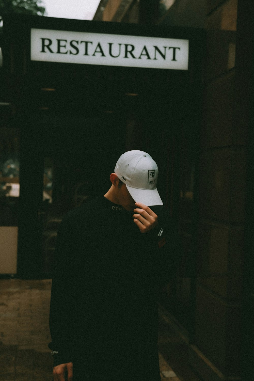 man in black long sleeve shirt wearing white cap