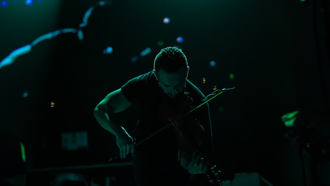 man in black t-shirt playing violin