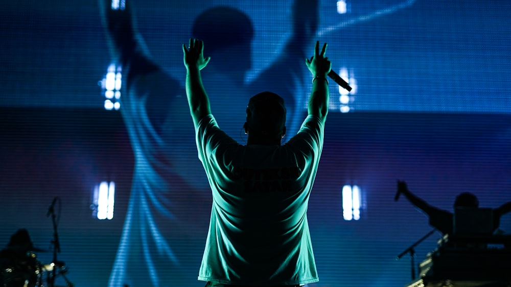 man in white long sleeve shirt raising his hands