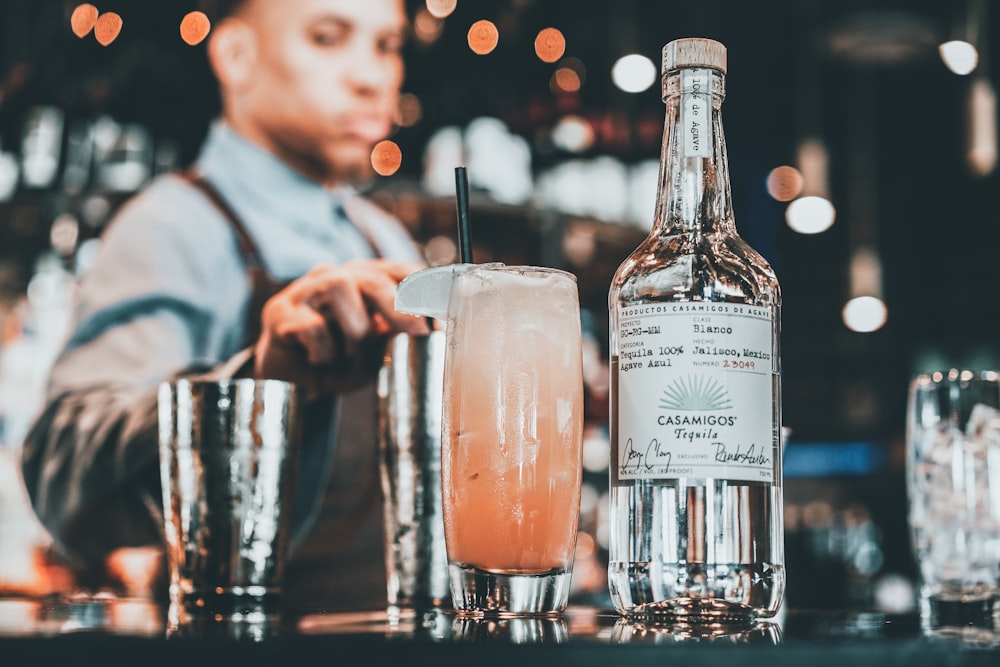 man in white dress shirt holding clear drinking glass