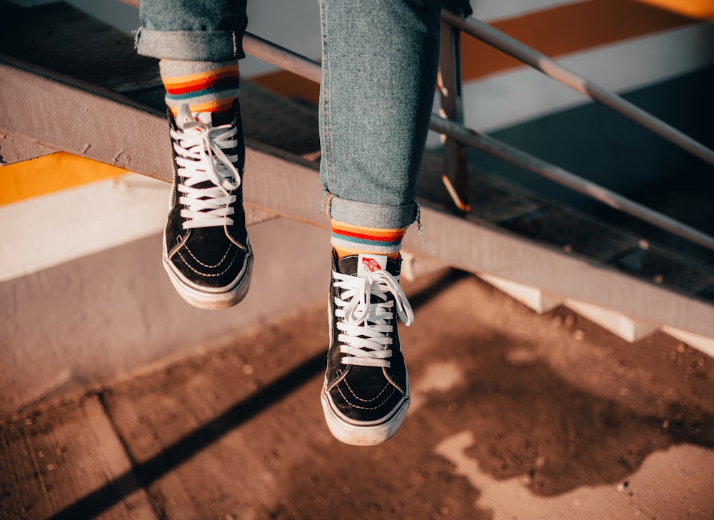 person in blue denim jeans and black and white sneakers