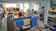 A well-organized store interior with neatly arranged products. Various home goods and decorations are displayed, including kitchenware, artificial flowers, and textiles. Shelves are filled with neatly stacked items, and the store is brightly lit with natural and artificial light.