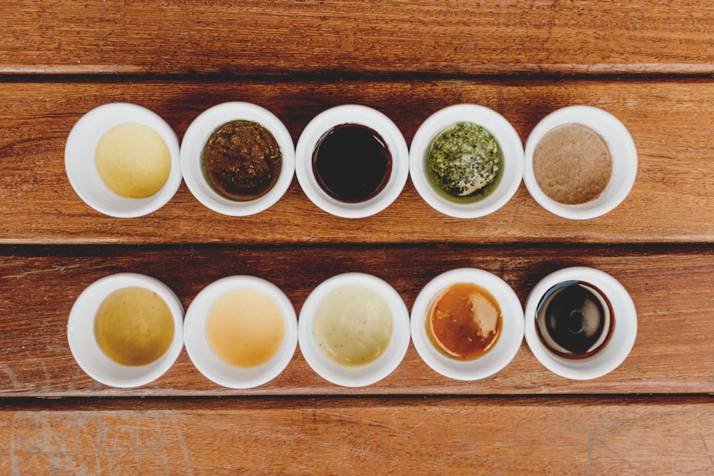 White ceramic cupping bowls arranged on a seasoned wooden tasting table — Jonathan Borba, Unsplash