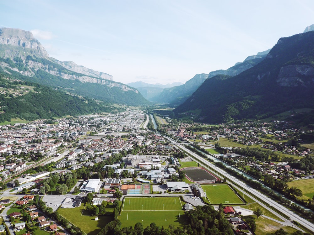 aerial view of city near green mountains during daytime