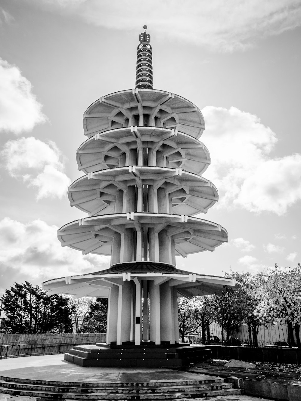 Bâtiment en béton blanc sous un ciel nuageux pendant la journée