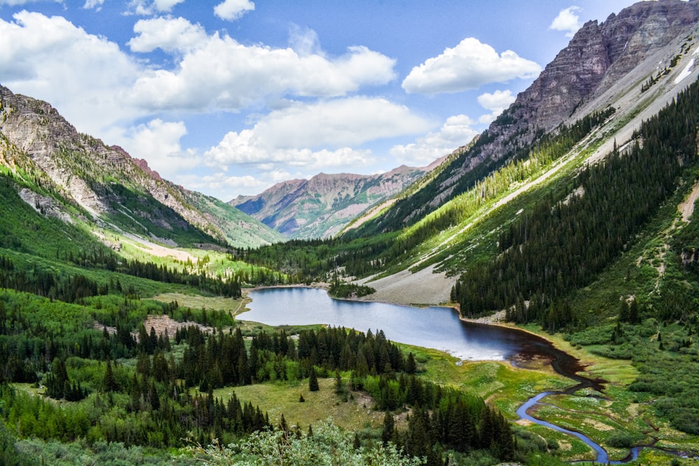 green mountains near river under blue sky during daytime