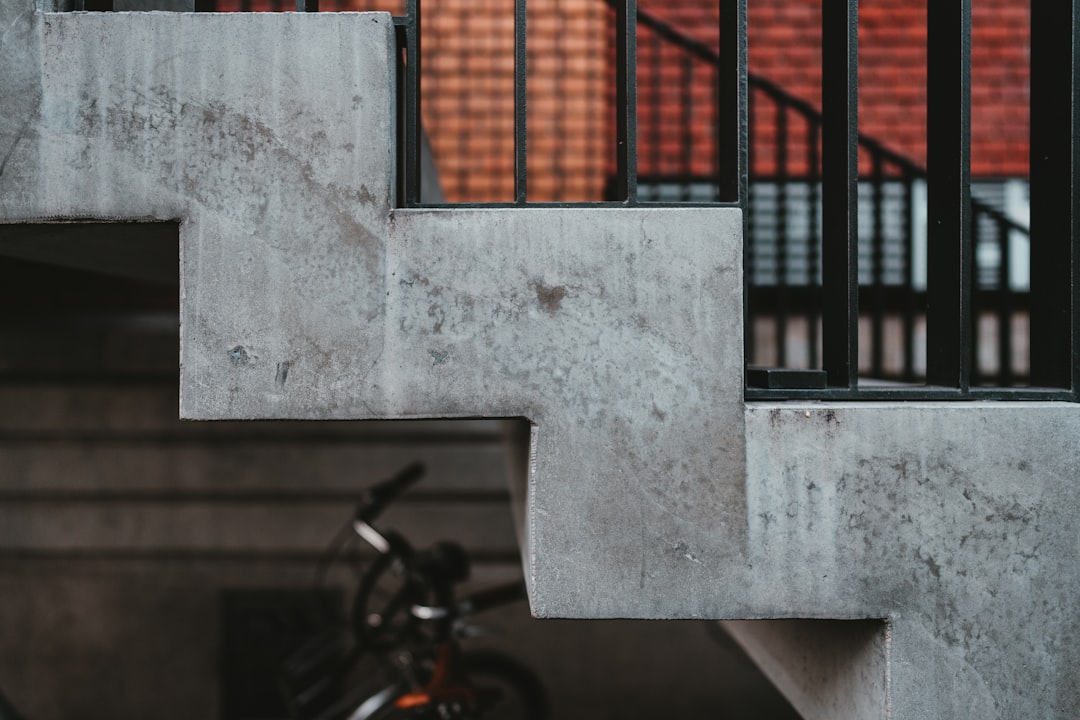 black bicycle parked beside white concrete wall