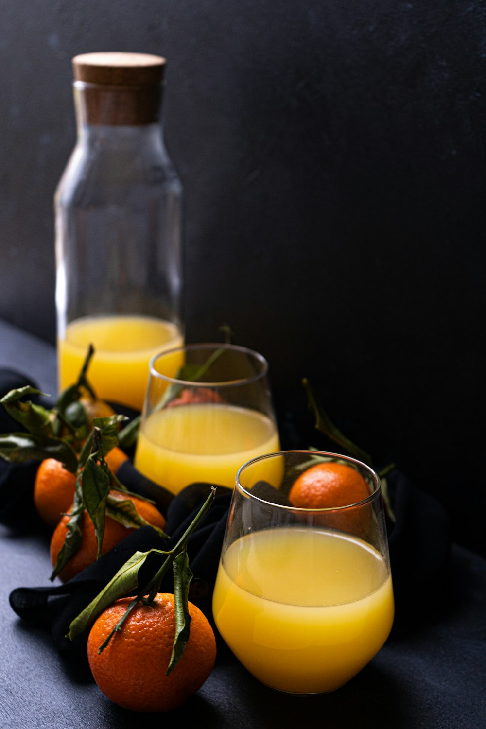 two clear drinking glasses with yellow liquid