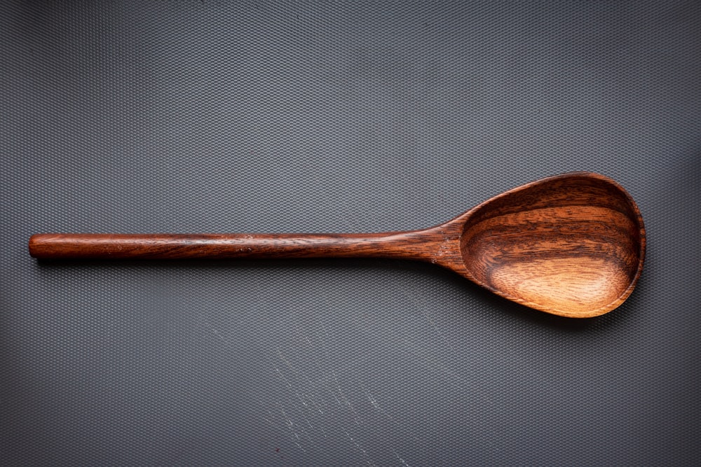 brown wooden spoon on white surface