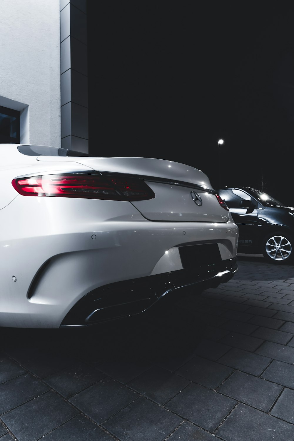 white car parked on sidewalk during night time