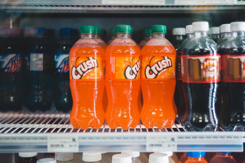 orange soda bottle on white shelf