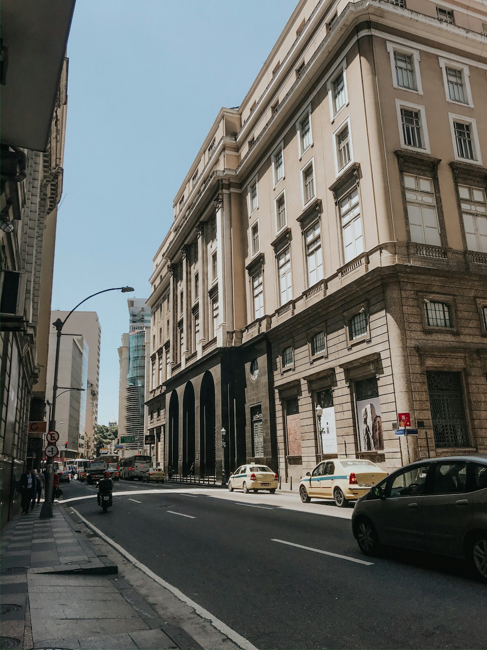 cars parked on side of the road near buildings during daytime