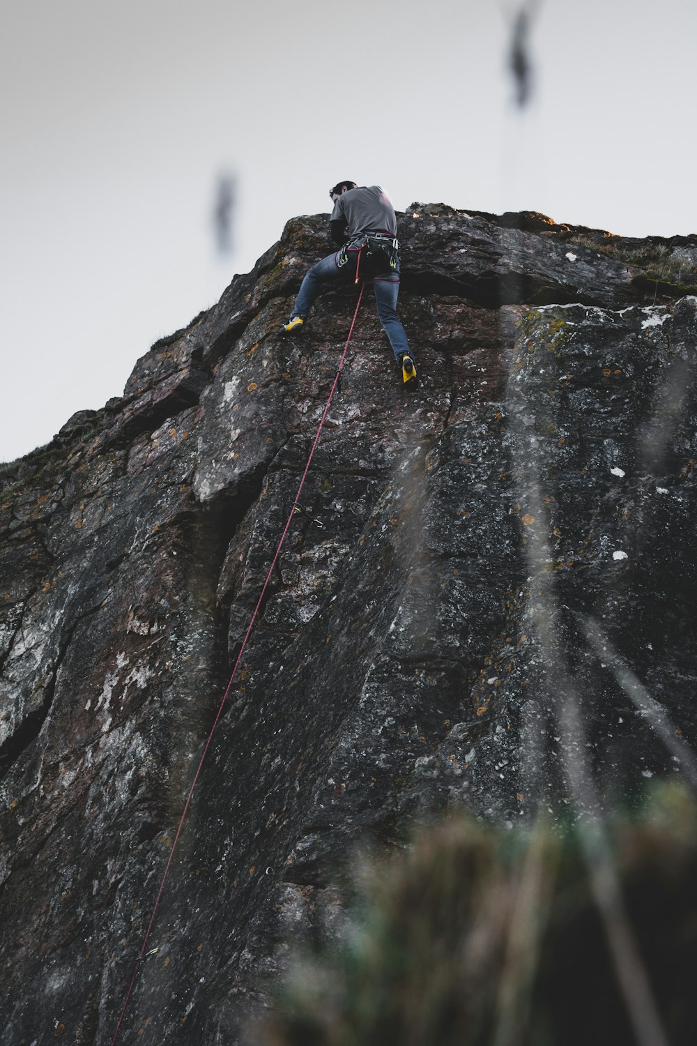 man in blue jacket climbing mountain during daytime
