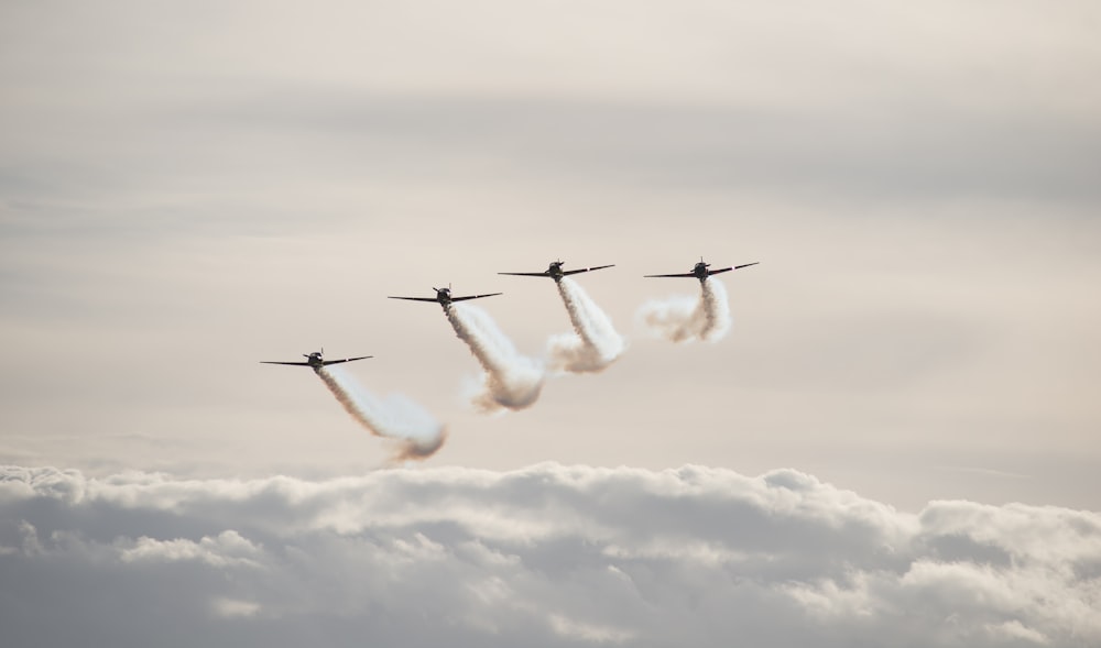 four white fighter planes flying in the sky during daytime