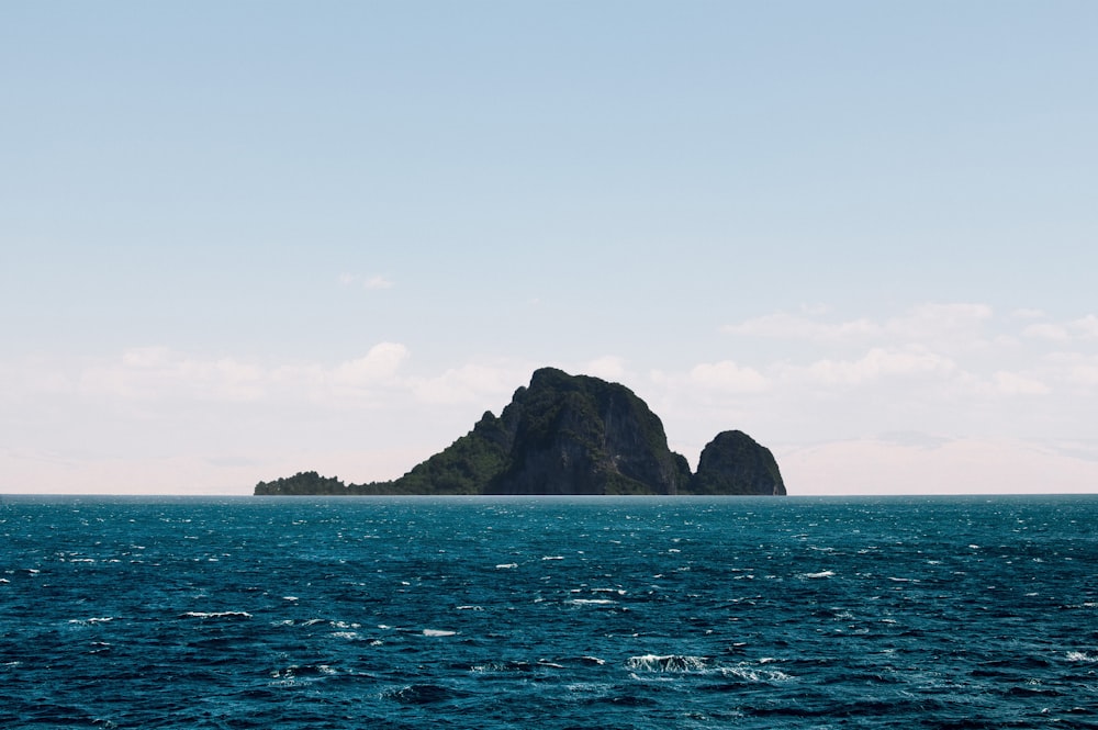 green and brown mountain beside body of water during daytime