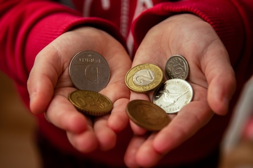 A close-up of hands gently holding a mix of gold and silver coins ready for appraisal.