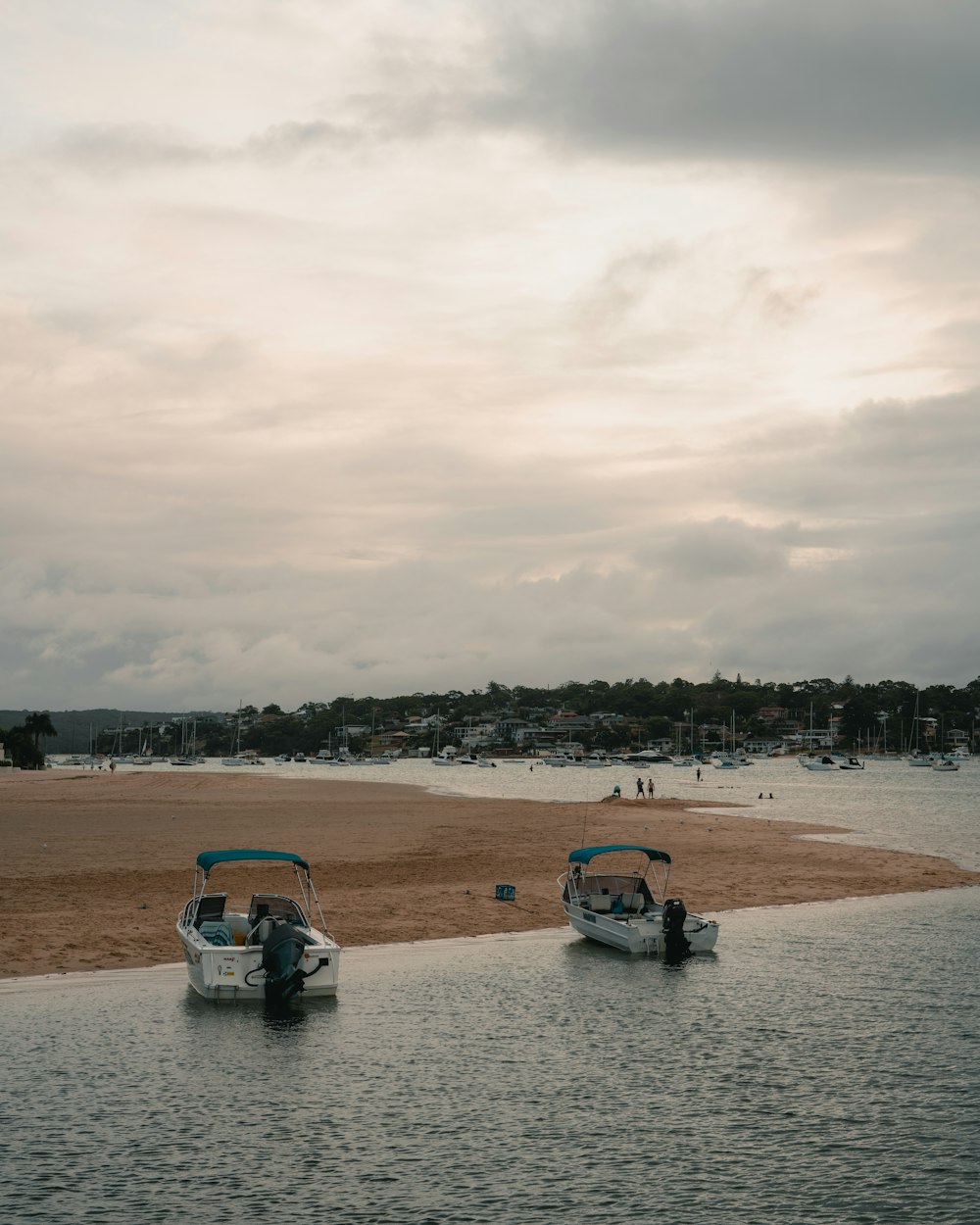 blue and white car on brown sand under cloudy sky during daytime