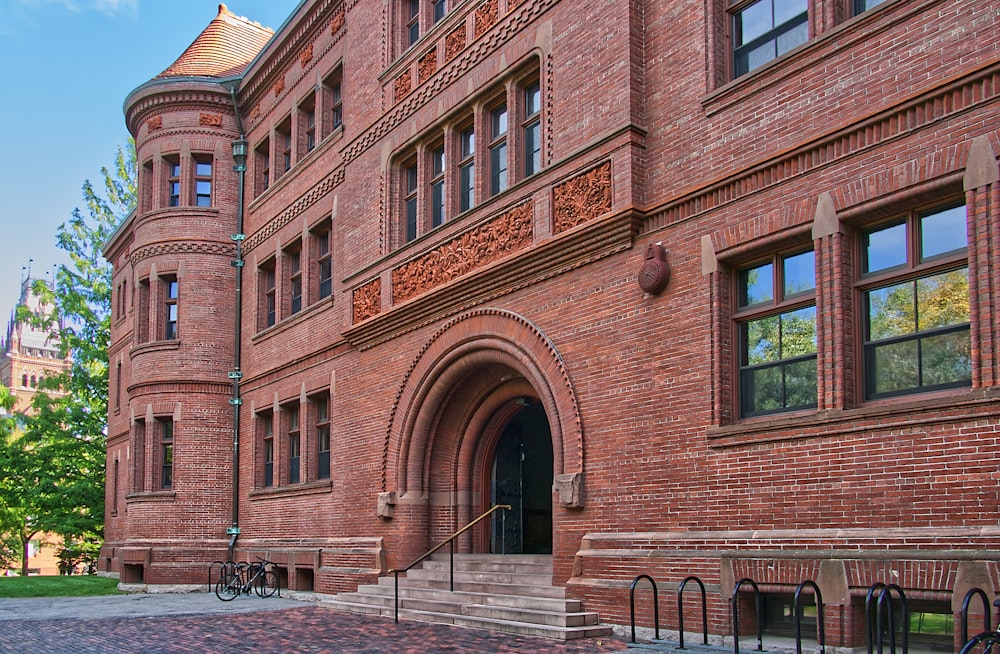 brown brick building with white wooden fence