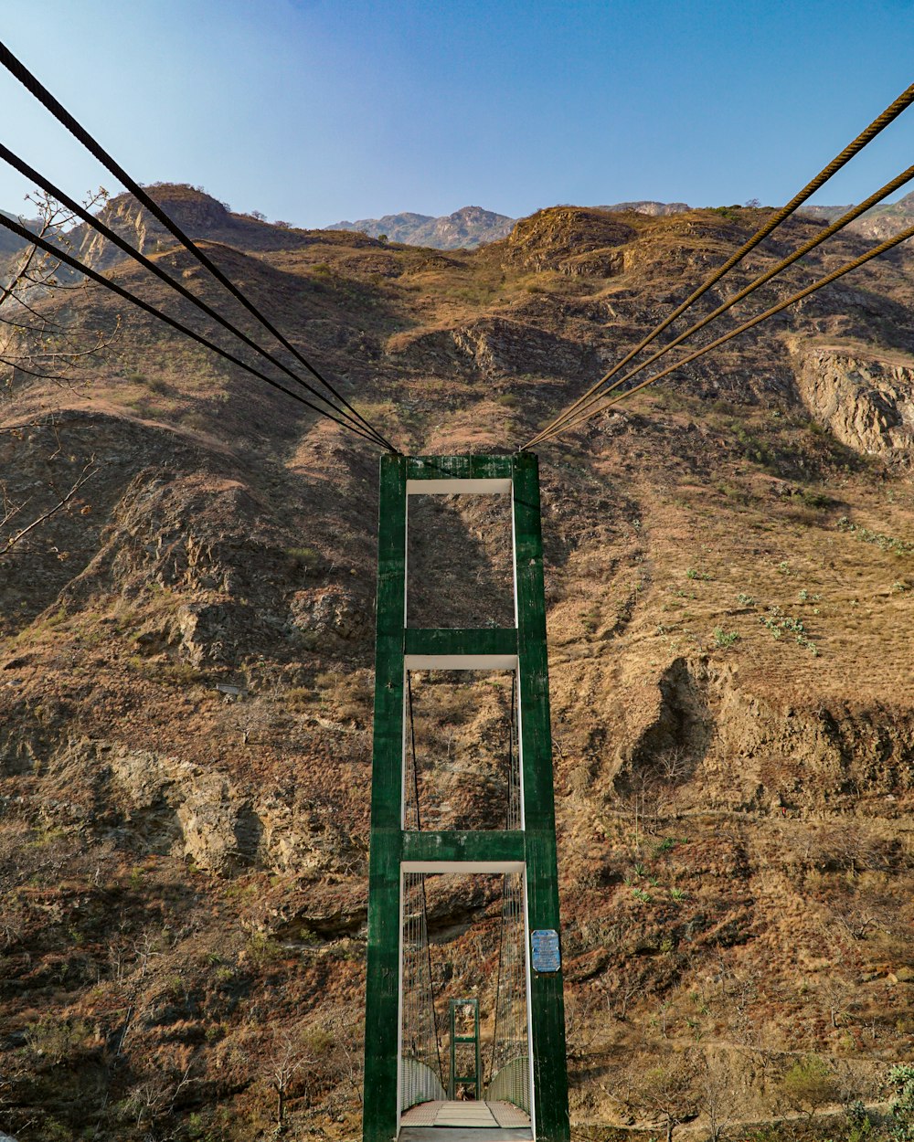 Escalera de metal verde en la montaña rocosa marrón durante el día