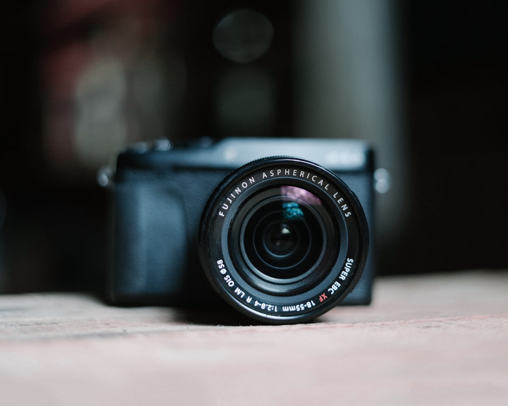 black nikon dslr camera on brown wooden table