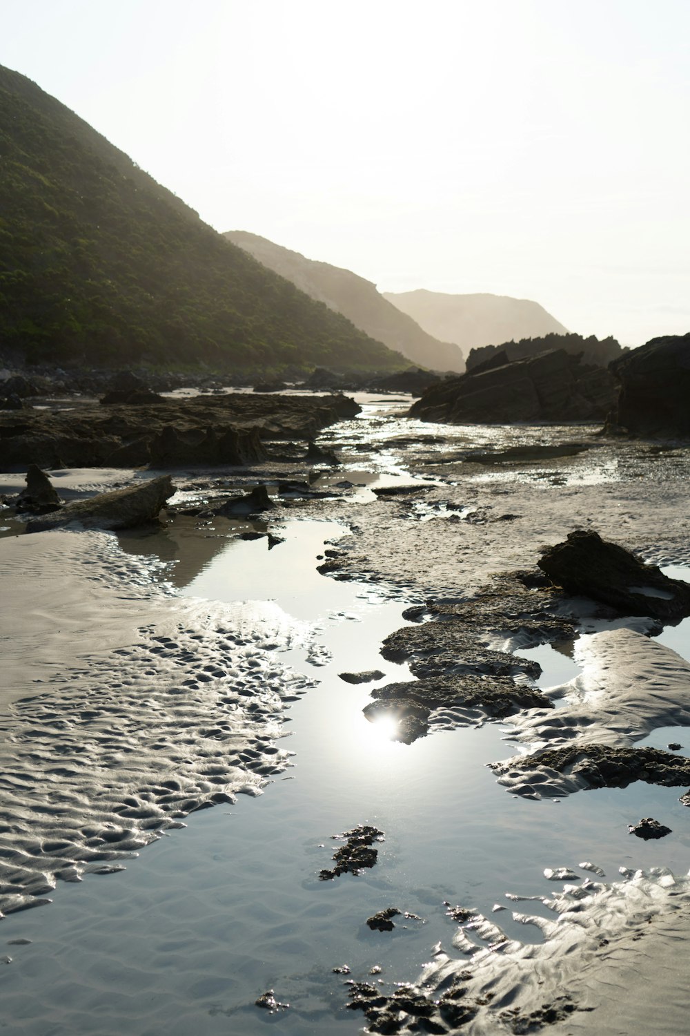 body of water near mountain during daytime