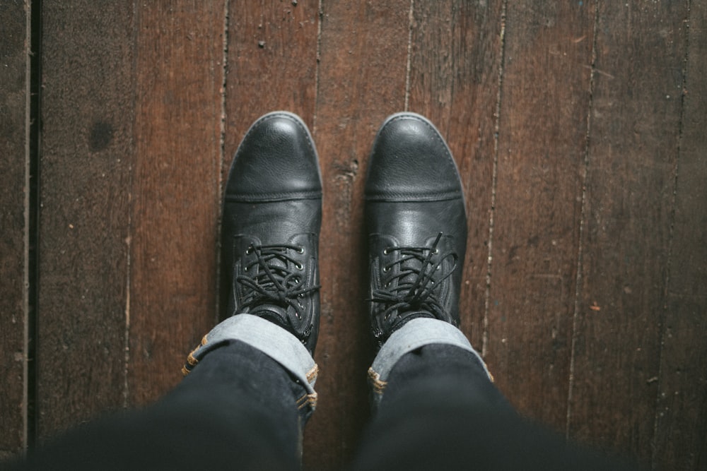 person wearing black leather shoes