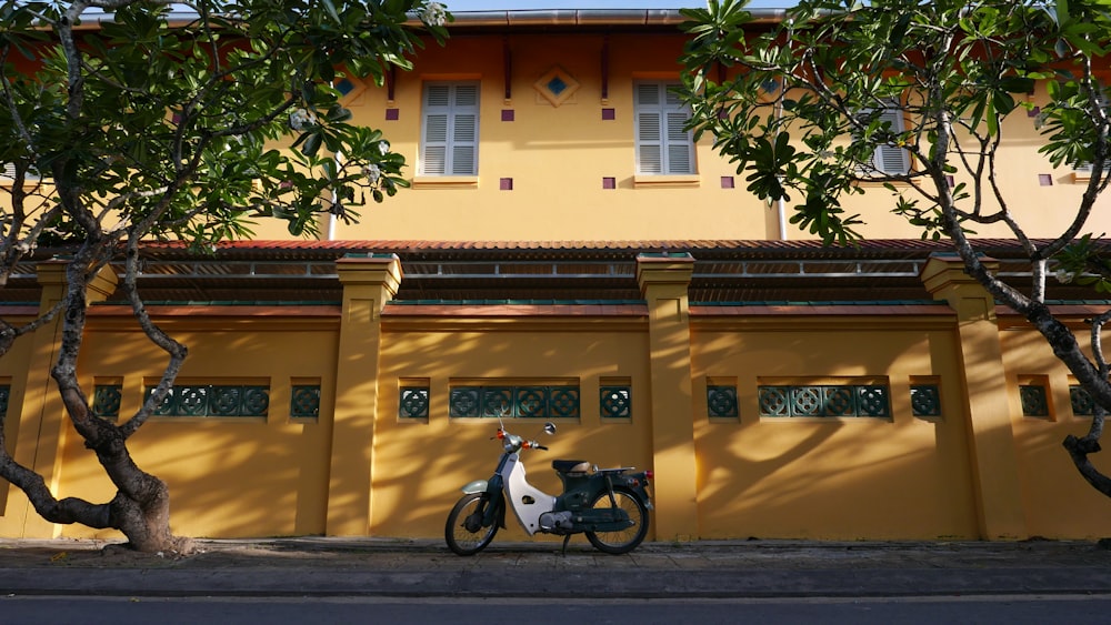 black motorcycle parked beside yellow concrete building