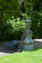A vibrant garden scene showcasing Sahirko's durable garden tools resting against a rustic fence.
