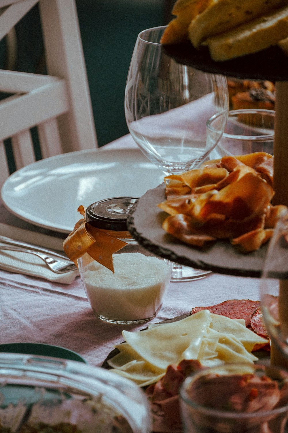 clear drinking glass beside brown and white cake on white ceramic plate