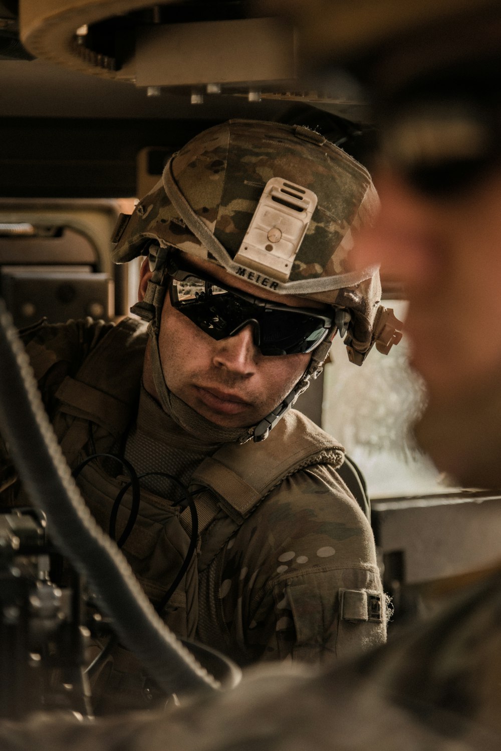 man in black and brown camouflage jacket wearing black sunglasses