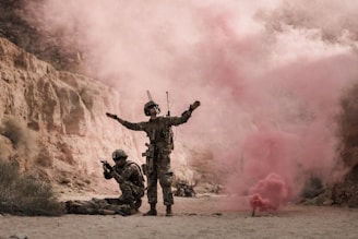 man in black and brown camouflage uniform holding red smoke