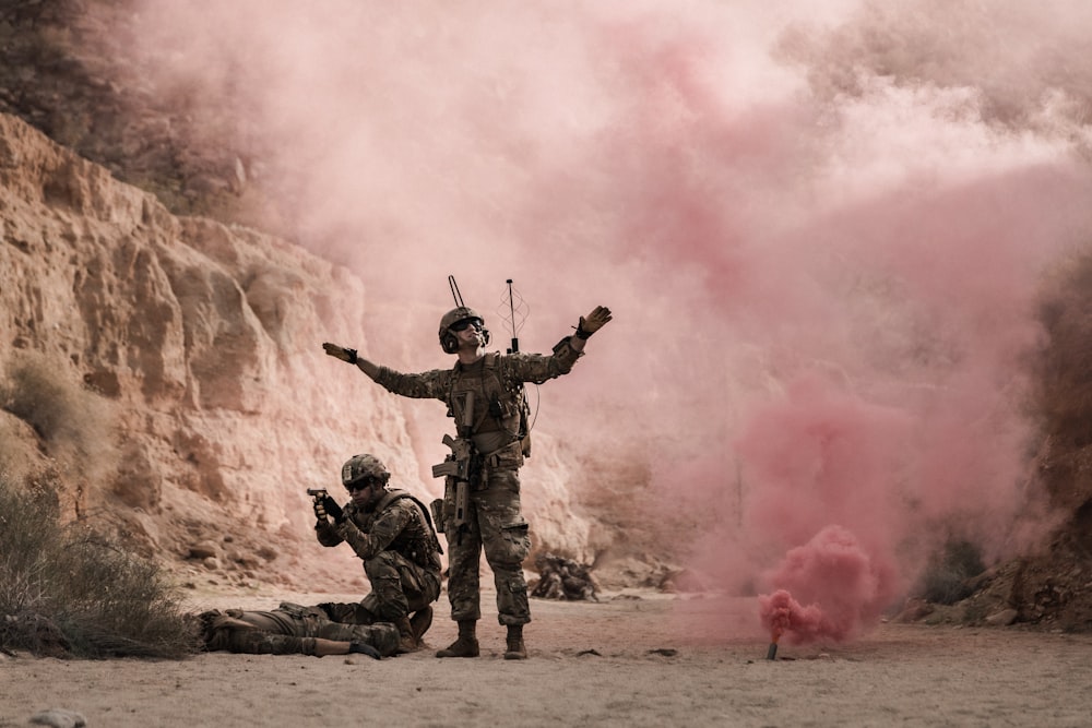 man in black and brown camouflage uniform holding red smoke