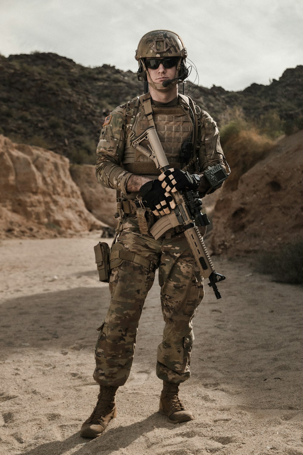 Hombre con uniforme de camuflaje marrón y negro sosteniendo un rifle