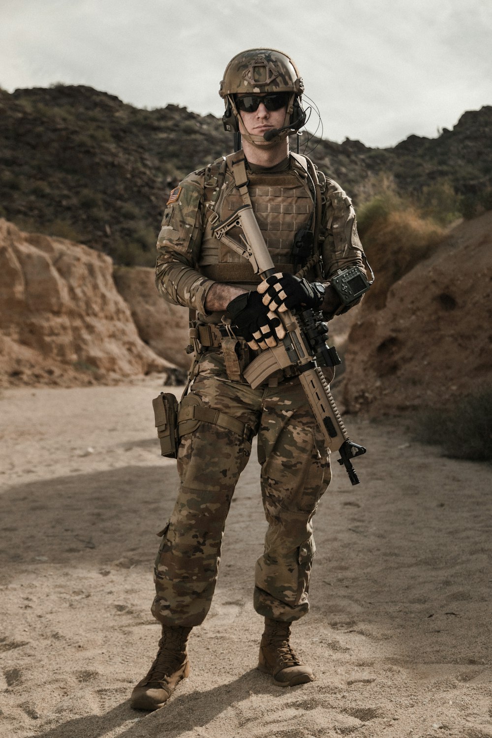 uomo in uniforme mimetica marrone e nera che tiene il fucile