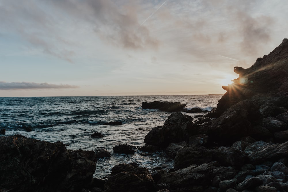 sea waves crashing on rocks during sunset