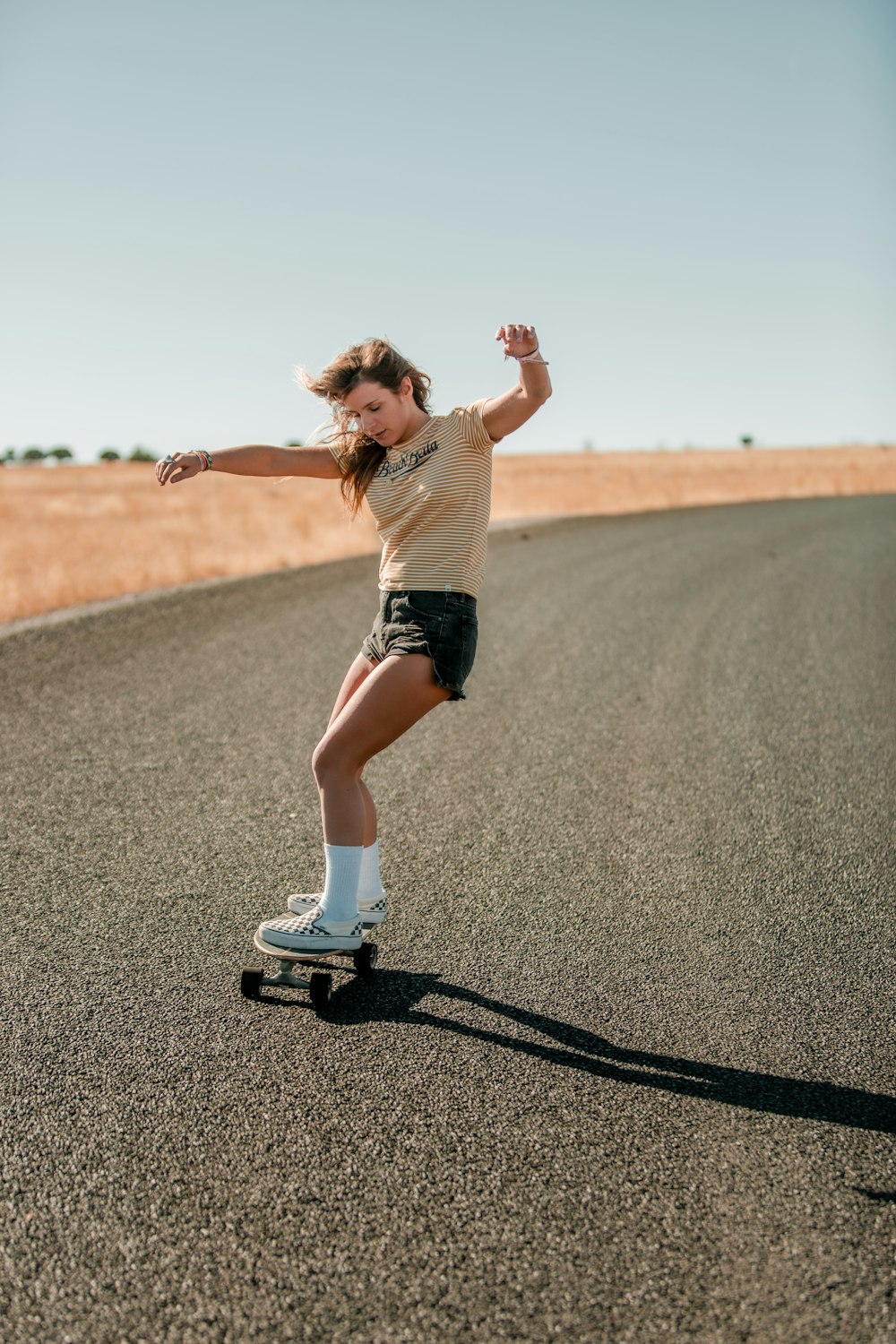 woman in white shirt and black shorts running on road during daytime