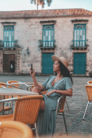 A traveler using the Nativo Trancoso app on their phone while sitting at a beach café.